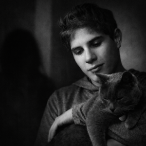 Fotografía en blanco y negro de Víctor sosteniendo a su gato en un momento previo a su detención, utilizada en la campaña JusticiaXVictor para solicitar revisión independiente del caso.